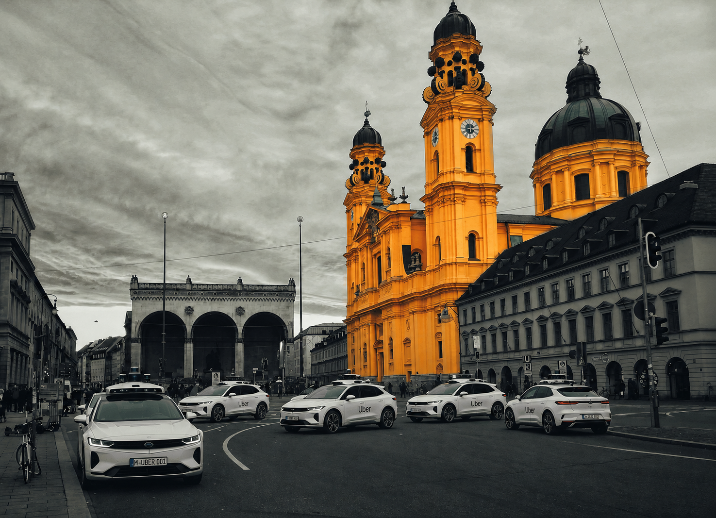 Беспилотное такси Убер - On Duty of Munich Bright yellow baroque church towers dominate a city street with Uber cars parked along the curb, gray surrounding buildings behind them.